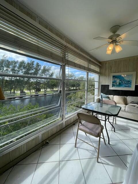 unfurnished sunroom featuring a water view and ceiling fan