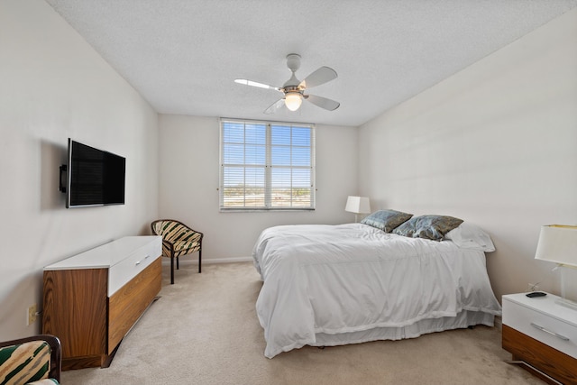 carpeted bedroom with ceiling fan and a textured ceiling