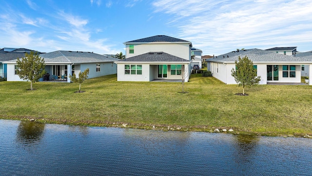 rear view of property with a water view and a yard