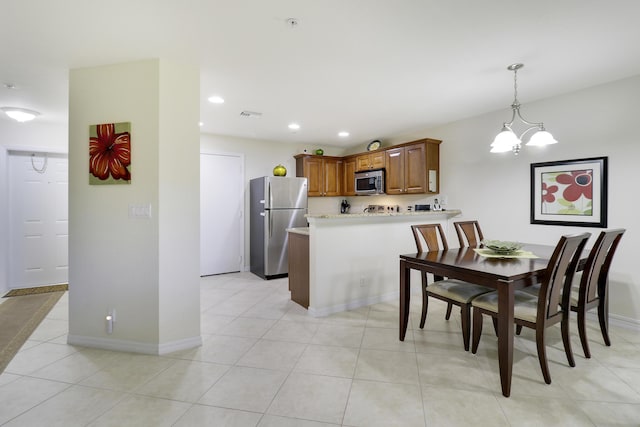 dining space featuring light tile patterned floors and a notable chandelier