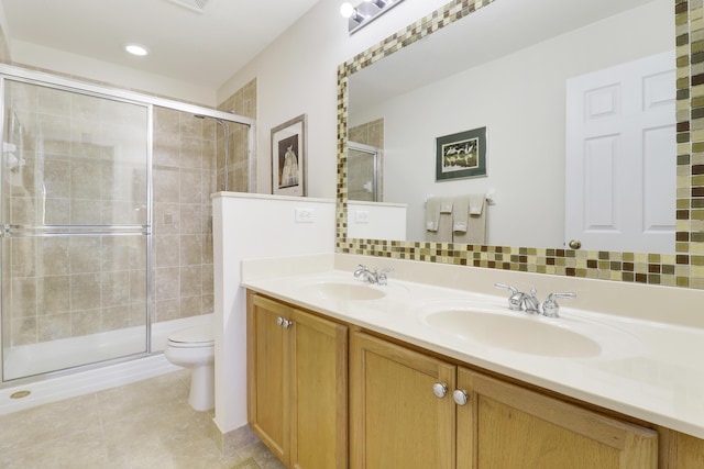 bathroom featuring walk in shower, vanity, toilet, and tile patterned flooring