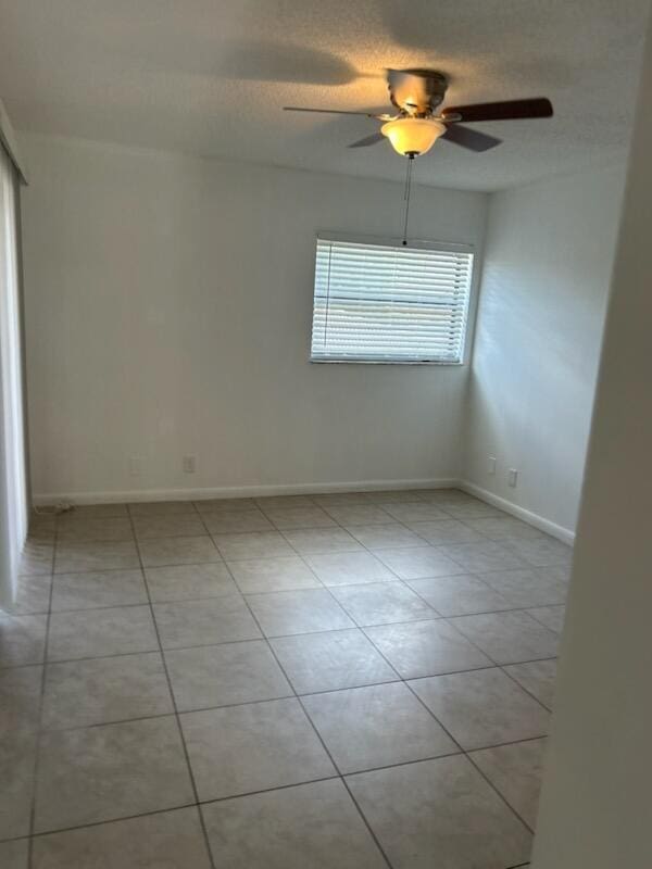 tiled spare room featuring ceiling fan and a textured ceiling