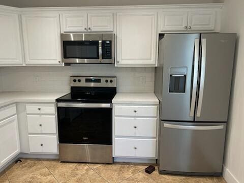 kitchen with white cabinetry, tasteful backsplash, light tile patterned flooring, and appliances with stainless steel finishes