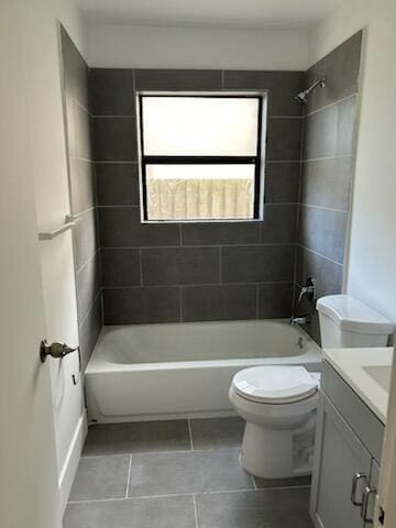 full bathroom featuring tiled shower / bath, vanity, toilet, and tile patterned floors