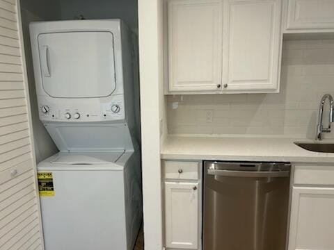 laundry area with stacked washer / dryer and sink