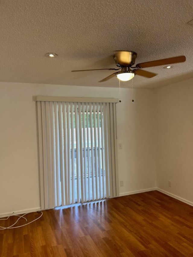 unfurnished room featuring hardwood / wood-style flooring and a textured ceiling