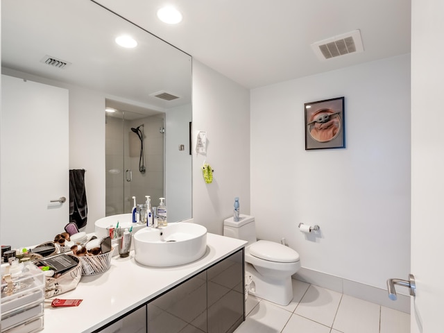 bathroom with vanity, a shower with shower door, tile patterned floors, and toilet