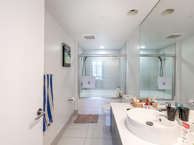 full bathroom featuring tile patterned flooring, vanity, bath / shower combo with glass door, and toilet