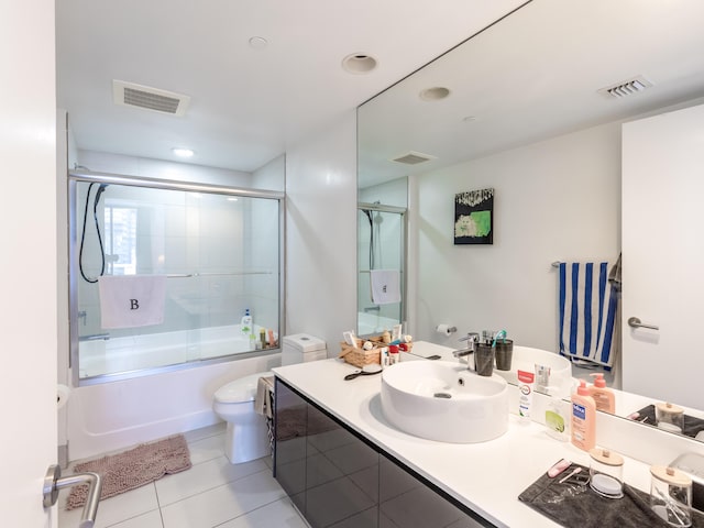 full bathroom with tile patterned flooring, vanity, shower / bath combination with glass door, and toilet