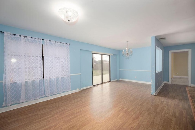 unfurnished room featuring hardwood / wood-style floors and a notable chandelier