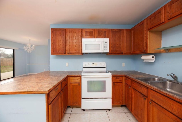 kitchen with light tile patterned flooring, sink, white appliances, kitchen peninsula, and an inviting chandelier