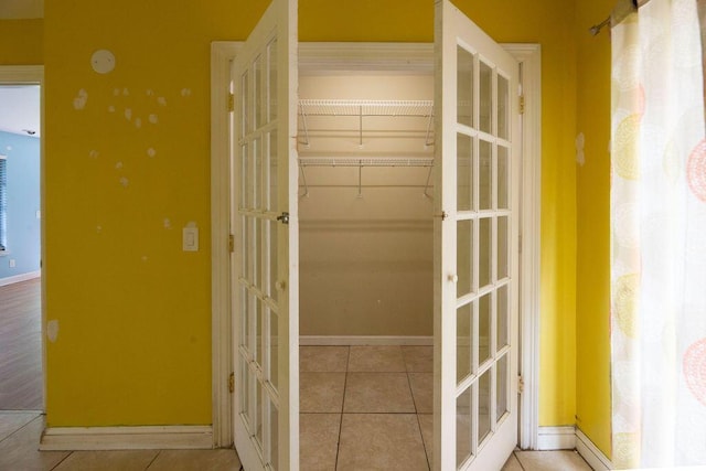 corridor featuring tile patterned flooring and french doors