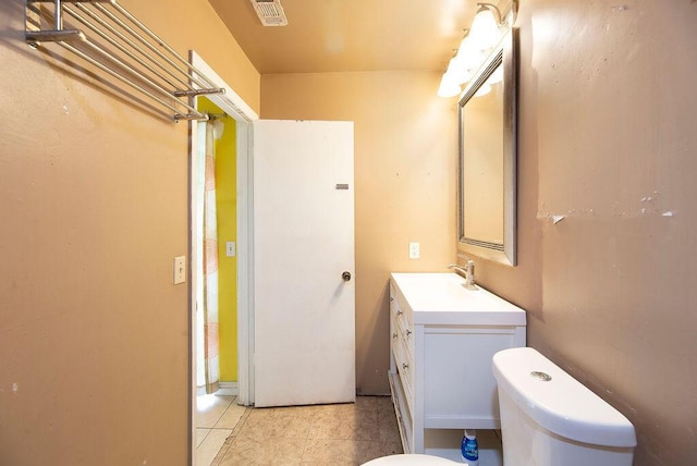 bathroom featuring tile patterned flooring, vanity, and toilet