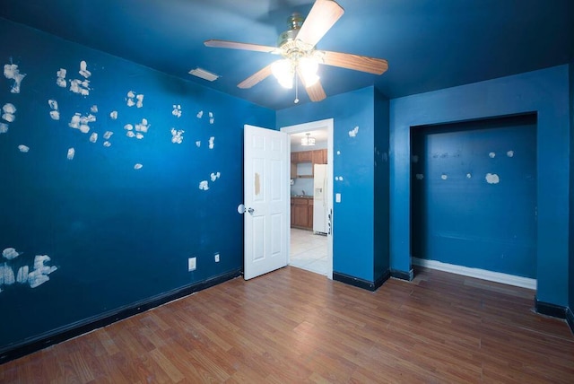 empty room with hardwood / wood-style flooring and ceiling fan