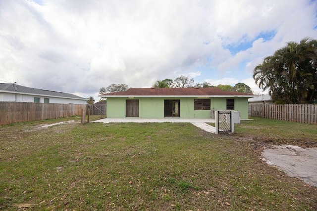 back of property with a patio area and a lawn