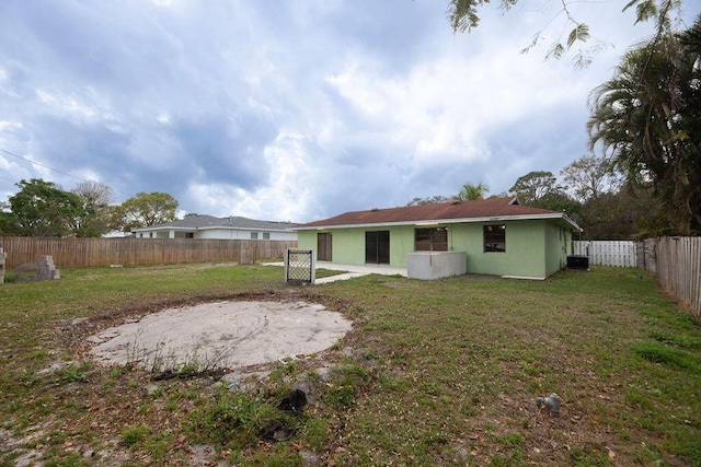 back of property with a lawn and a patio area