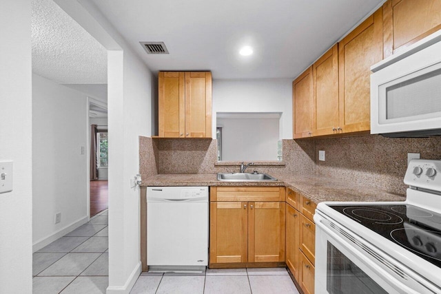 kitchen featuring tasteful backsplash, sink, light stone counters, and white appliances