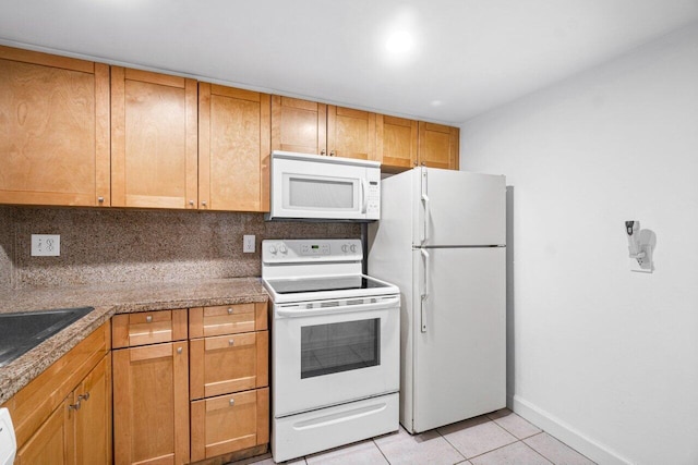 kitchen with stone countertops, sink, decorative backsplash, light tile patterned floors, and white appliances