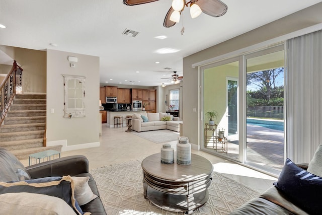 living room featuring ceiling fan, plenty of natural light, and light tile patterned floors