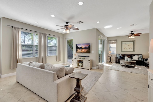 tiled living room featuring ceiling fan and plenty of natural light