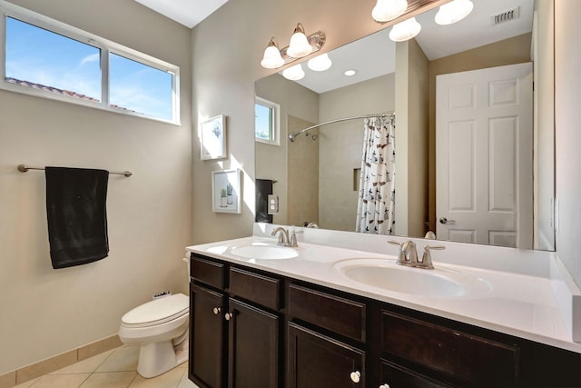 bathroom featuring tile patterned flooring, vanity, toilet, and walk in shower