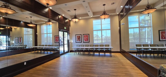 workout area featuring coffered ceiling and a towering ceiling