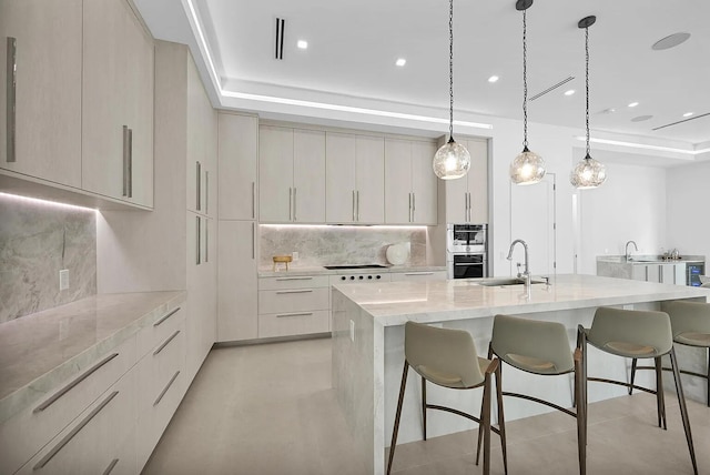 kitchen with pendant lighting, sink, a kitchen breakfast bar, a spacious island, and tasteful backsplash