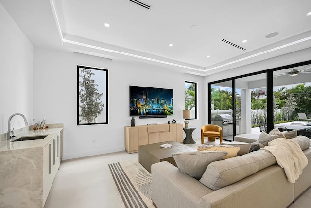 living room with indoor wet bar and a tray ceiling