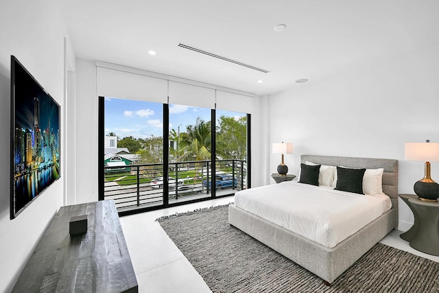 bedroom featuring concrete flooring, expansive windows, and access to outside