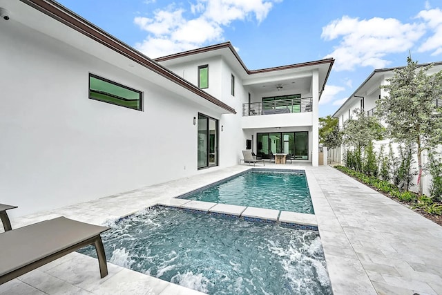 back of property with ceiling fan, a balcony, and a patio area