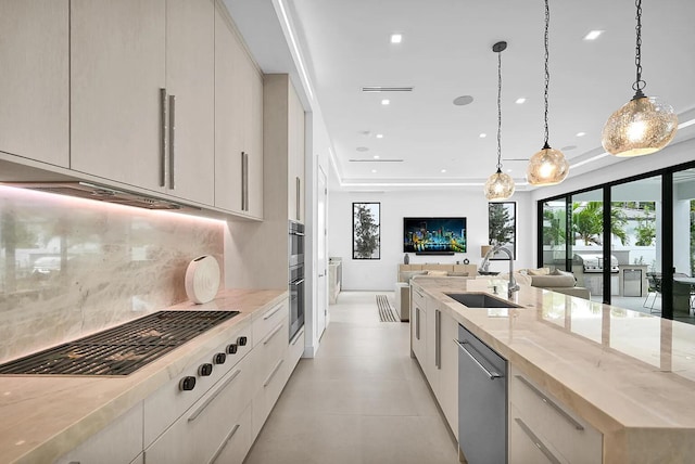 kitchen featuring sink, hanging light fixtures, stainless steel dishwasher, light stone countertops, and backsplash