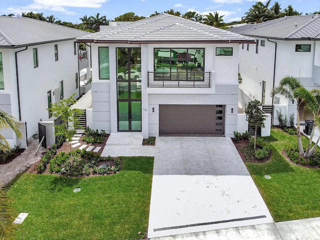 view of front of property with a garage, central AC unit, and a front yard