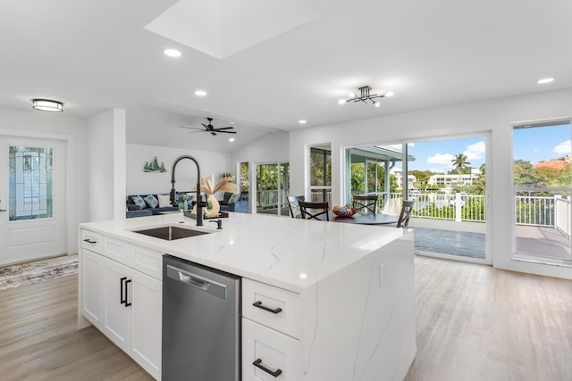 kitchen featuring white cabinetry, a sink, an island with sink, light stone countertops, and dishwasher