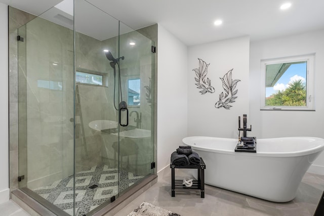 bathroom featuring a stall shower, a soaking tub, baseboards, and recessed lighting