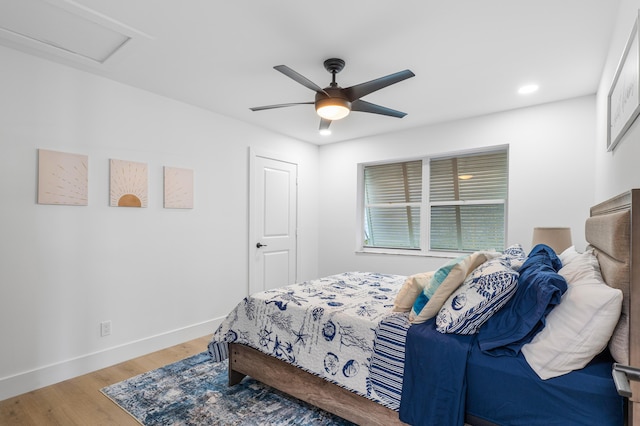 bedroom featuring recessed lighting, light wood-style floors, attic access, ceiling fan, and baseboards