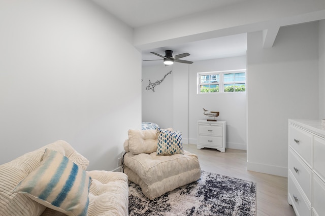 living area featuring ceiling fan and baseboards