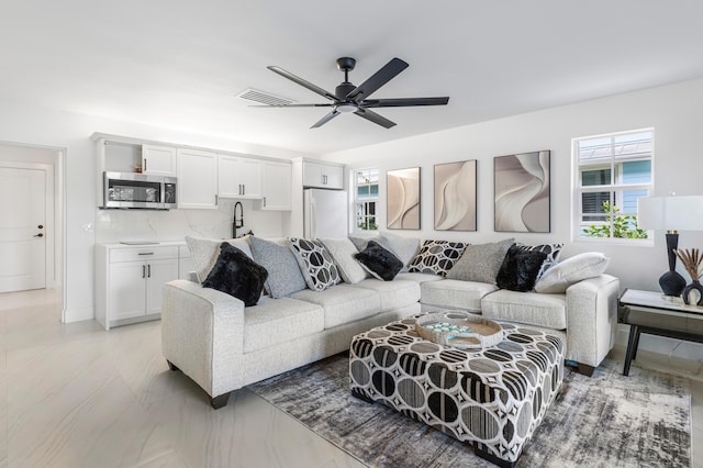 living room with ceiling fan and visible vents