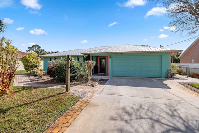 ranch-style house featuring stucco siding, driveway, fence, an attached garage, and metal roof