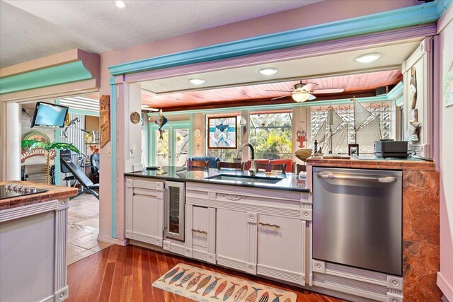 kitchen featuring sink, white cabinetry, wine cooler, stainless steel dishwasher, and light wood-type flooring