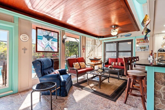 sunroom with ceiling fan, sink, and wood ceiling