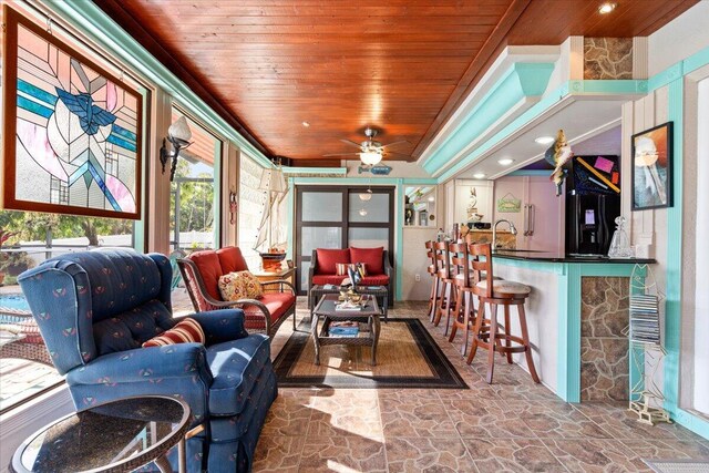 sunroom featuring ceiling fan and wooden ceiling