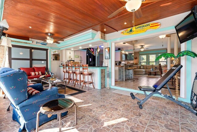 living room featuring ceiling fan and wooden ceiling