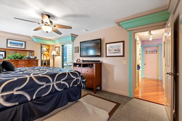 tiled bedroom featuring ceiling fan and a textured ceiling