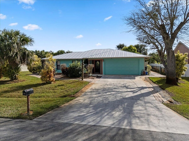 ranch-style house featuring metal roof, a front yard, concrete driveway, and an attached garage