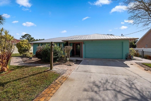 ranch-style house featuring fence, driveway, and metal roof