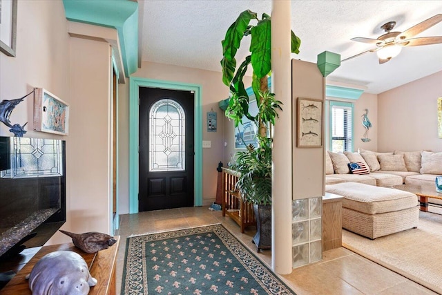 tiled entryway featuring ceiling fan and a textured ceiling