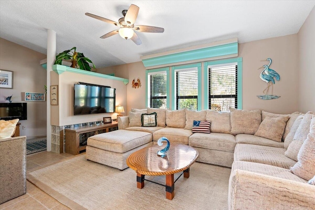 tiled living room with vaulted ceiling, a textured ceiling, and ceiling fan