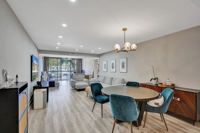 dining area featuring a notable chandelier and light hardwood / wood-style flooring