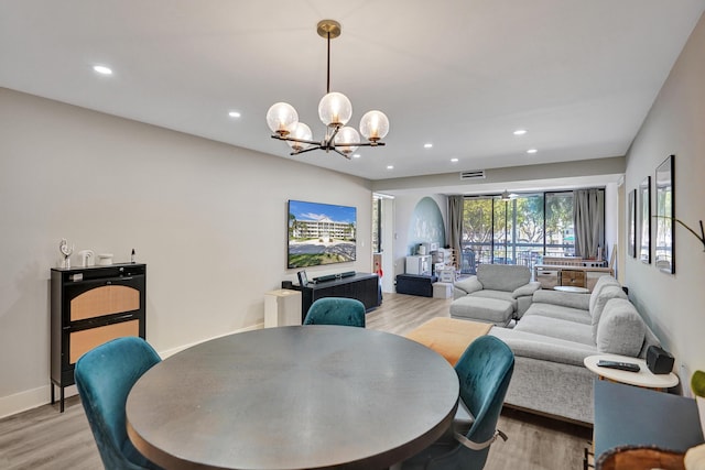 dining space with an inviting chandelier and light hardwood / wood-style floors