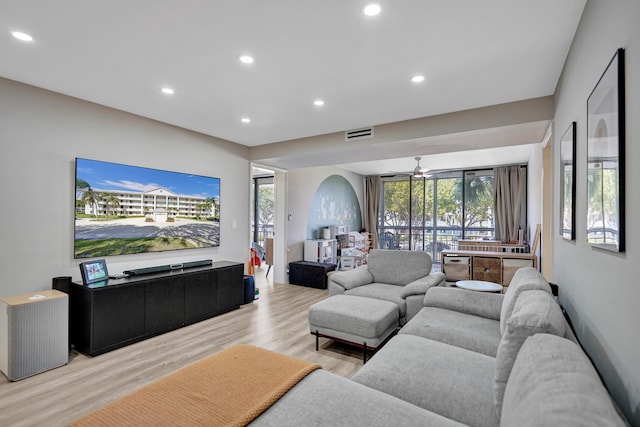 living room with light hardwood / wood-style flooring and ceiling fan